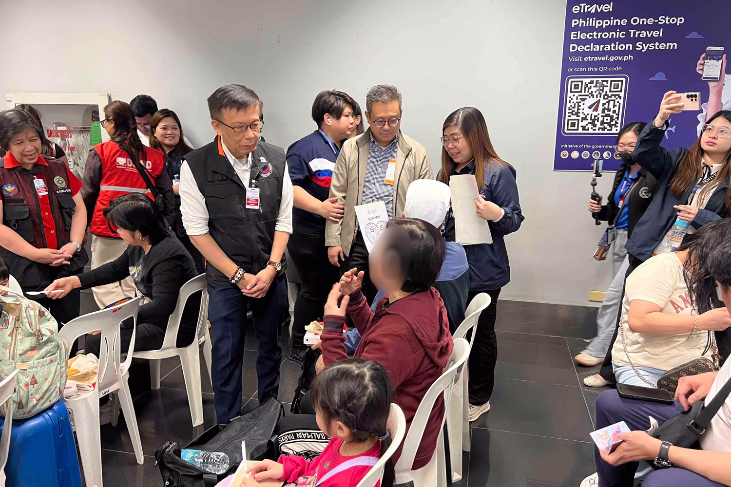 ニノイアキノ国際空港で中東から帰国したＯＦＷたちに声をかけるカクダク移民労働者相