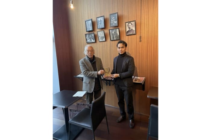 『鳳梨の織糸』英語版を贈呈する作者の川上佳風氏(右)と倉本幸弘氏、「森鴎外記念会通信」編集責任者)(左)