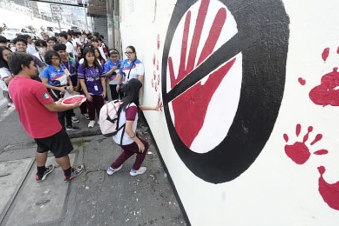 いじめ防止壁画プロジェクトの一環としてケソン市クバオのラモン・マグサイサイ高校の壁に描かれた赤い手形