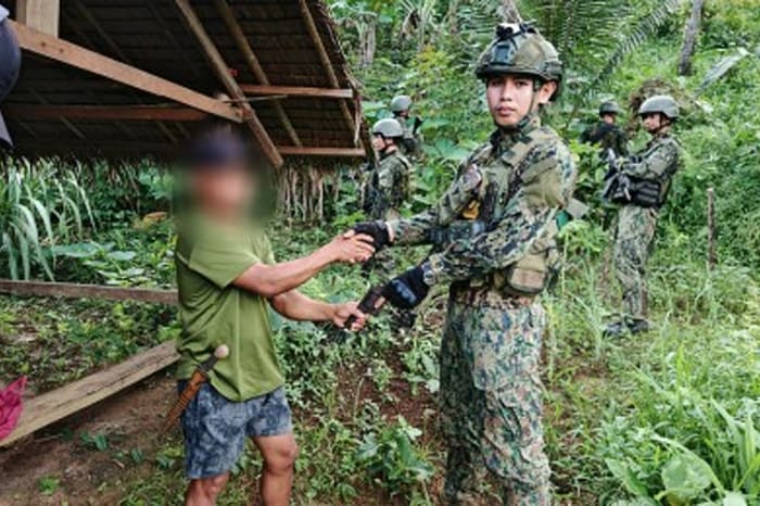 投降して国軍兵に銃を引き渡すNPA構成員