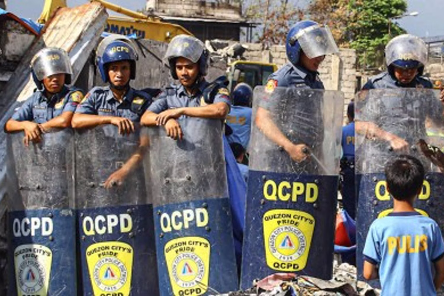 違法占拠住民居住区で発生した火災の片付け作業を警備する首都圏警察ケソン署の警官ら