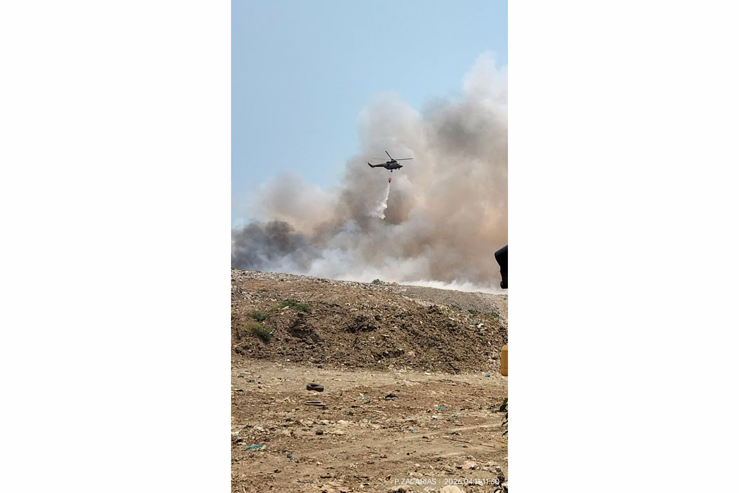 11日に衛生埋立跡地で消火にあたるヘリ