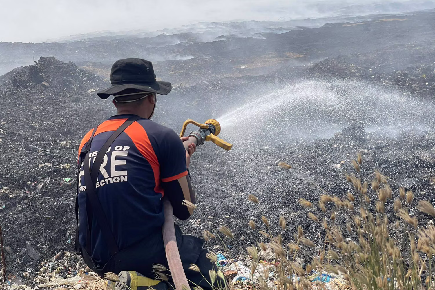 ナボタス市の衛生埋立処分場の火災で消火活動を行う消防庁職員