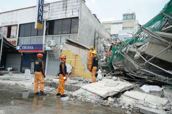 Rescuers beside the collapsed building in Pampanga. Bureau of Fire Protection