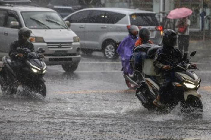 首都圏エドサ通りを雨の中走行する車やバイク