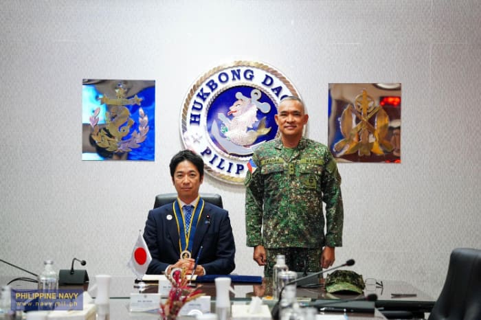 維新の藤田共同代表（左）とアマダル海軍副司令官