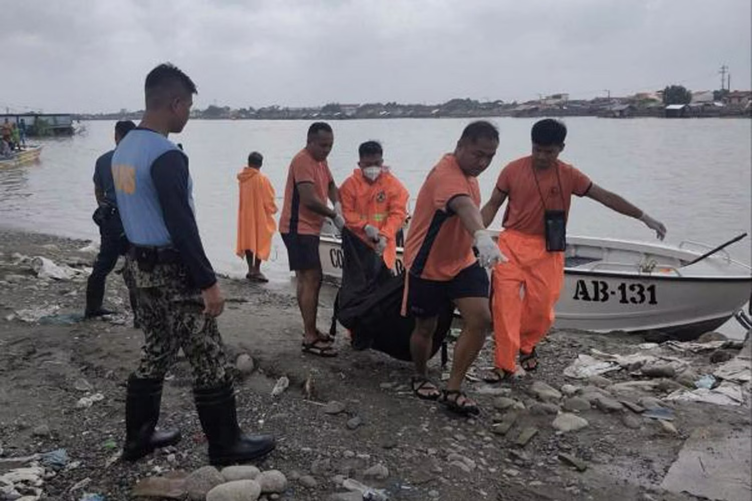 Coast Guard personnel carry the body of one of the passengers in a car that fell into a river after a part of the Agana Bridge in Tarlac collapsed. Philippine Coast Guard