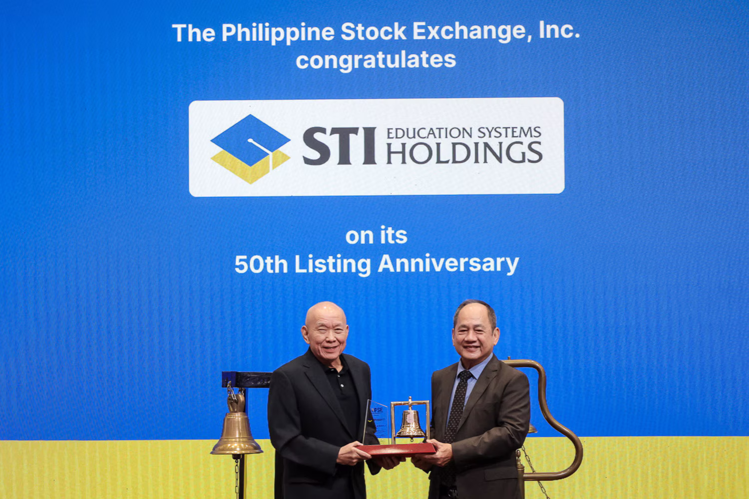 ＰＳＥのモンソン社長兼ＣＥＯ（左）が、ＳＴＩのタンコ会長に上場50周年記念の盾を贈った