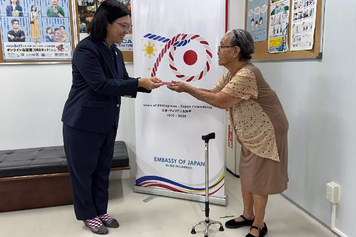 Adelaida Kakazu (right), receives her Japanese passport from Maya Hamada, Minister-Counselor and Consul General of the Japan Embassy on Friday. Robina Asido/PHS
